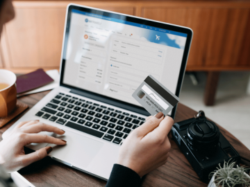 Someone looking at their credit card while at a computer