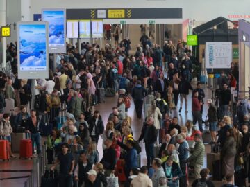 Passengers queue in line at Brussels Airport where dozens of flights were cancelled on Sunday. Photo: EPA