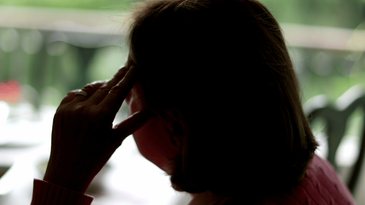From Fitbit to financial despair: How one woman lost her life savings and more to a scammer Back of woman with her head in her hand