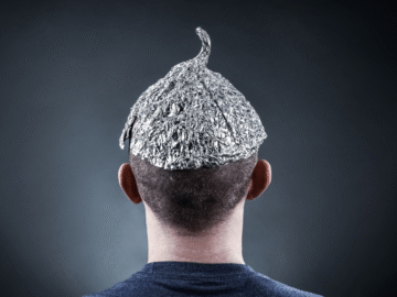 A man facing away from the camera wearing a tin foil hat