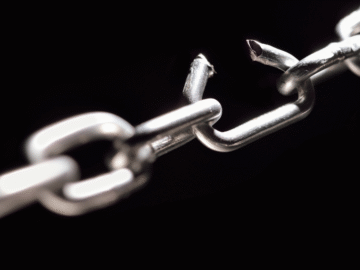 A broken metal chain on a black background